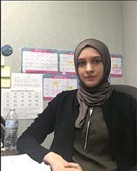Dr. Ansam Al-Aqtash, CMU Mathematics Alumnus, poses at her desk.
