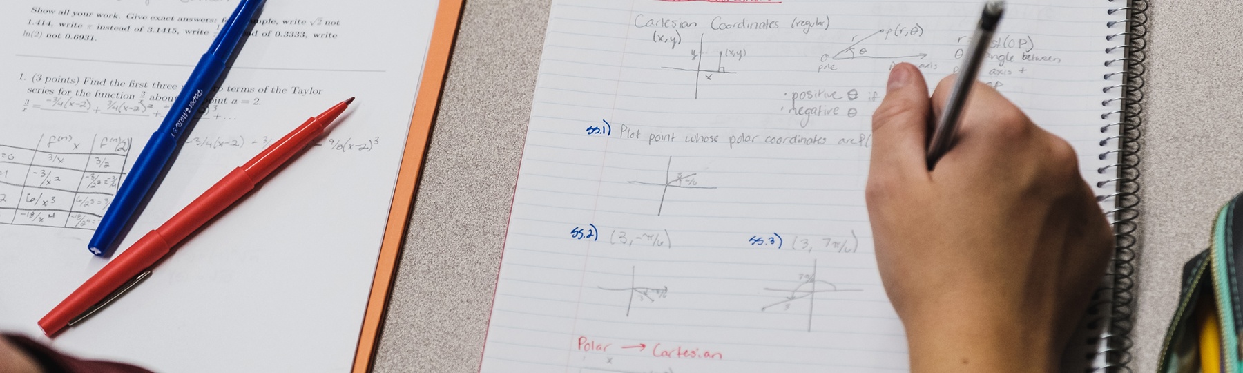 A student works on math problems in a notebook.