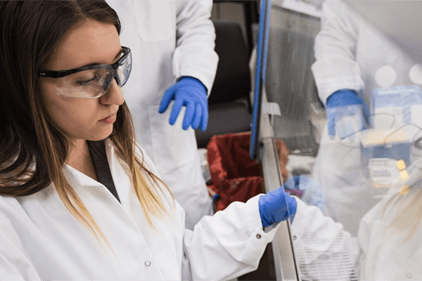 Neuroscience student examining samples in lab environment.