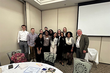 Dr. Pat Kinnicutt from the Department of Computer Science posing with a group of students participating in the MWC3 Conference.