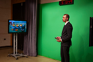 a man in a suit in front of a green screen