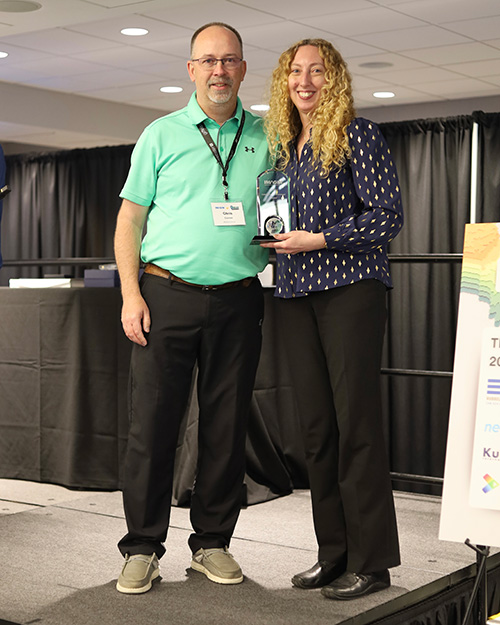 20250619_CantrellAward A man and a woman standing on a stage holding an award between them.