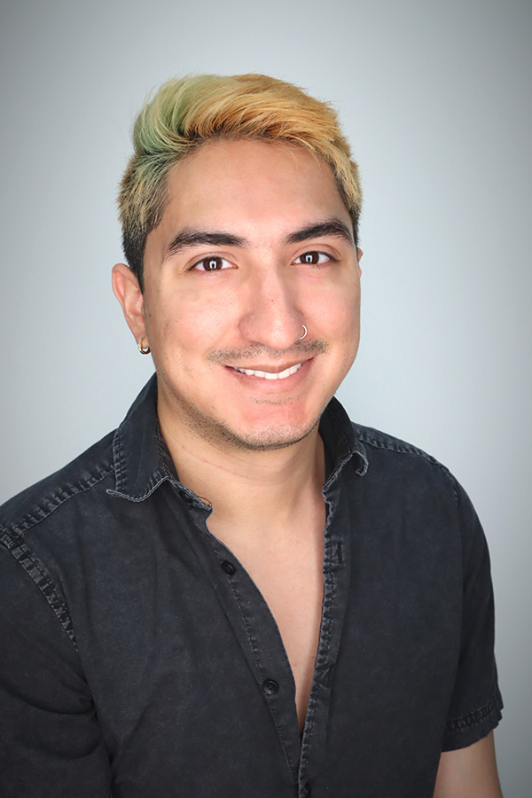 20250902_LinoG A man in a dark shirt and light colored hair in front of a light colored background.