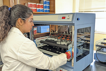 Yasna Mortezaei examining wastewater samples in a lab environment.
