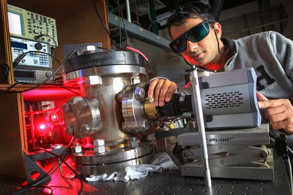 Physics doctoral student conducting experiment with laser.