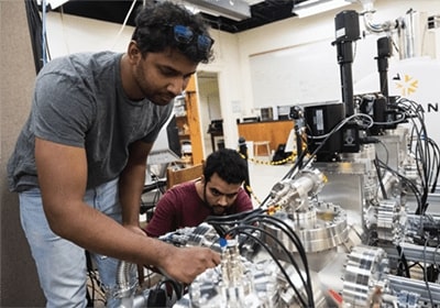 Physics graduate students setting up lab equipment for an experiment.