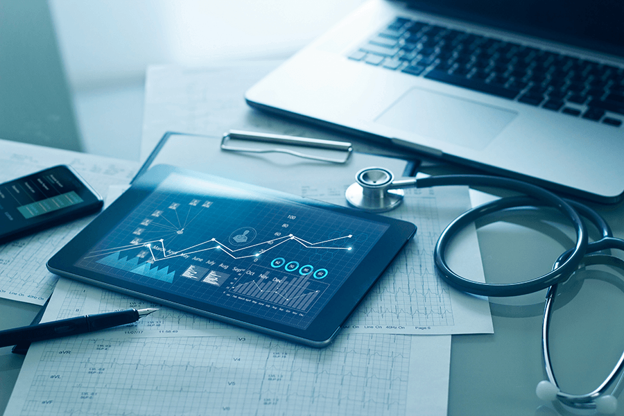 A tablet shows an increasing graph next to a stethoscope.