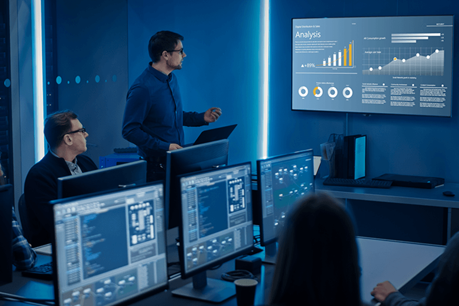 A data engineer reviews results on a large screen.