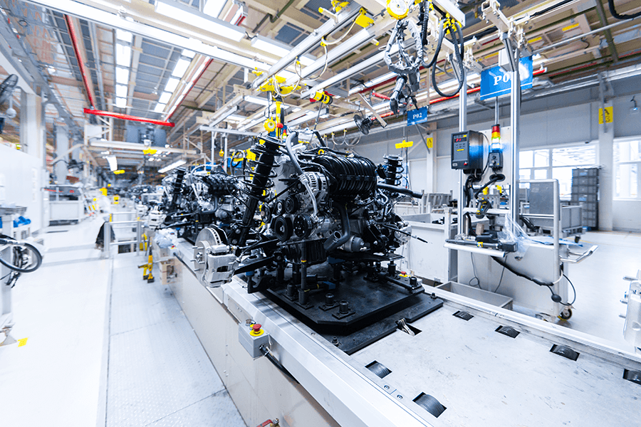 Machines work on an engine on an assembly line.