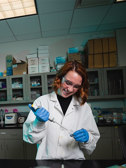 A student working with a pipette in a neuroscience lab.