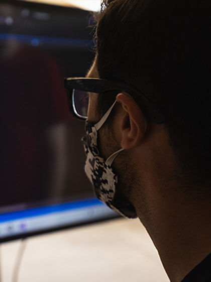 Student in mask examining computer code