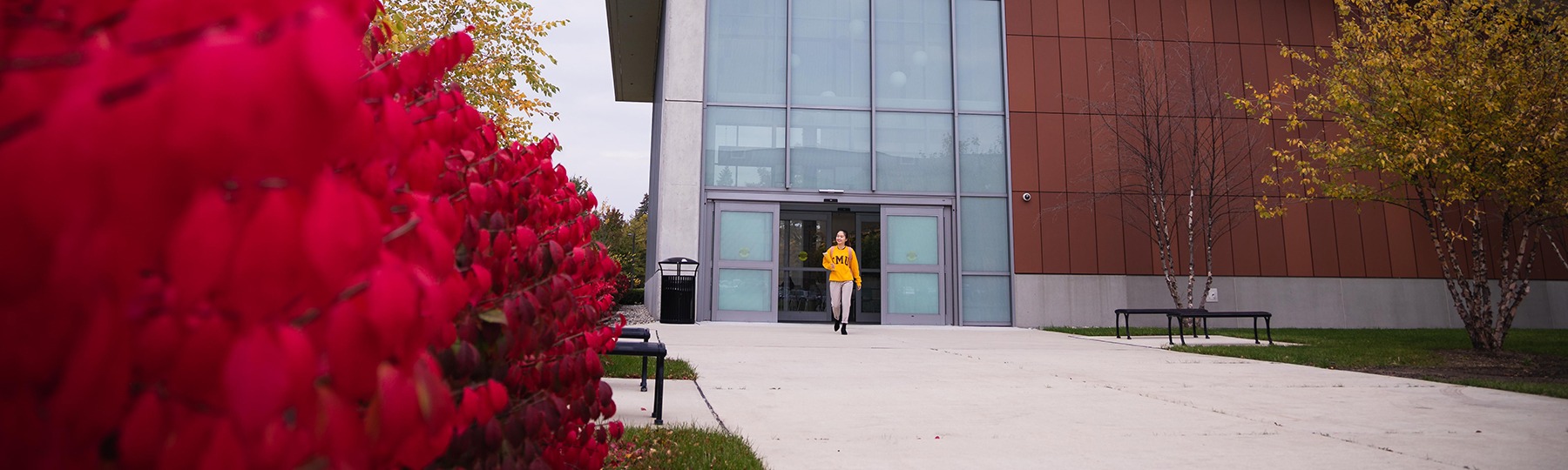 A student in a yellow shirt exits the BioSciences building.