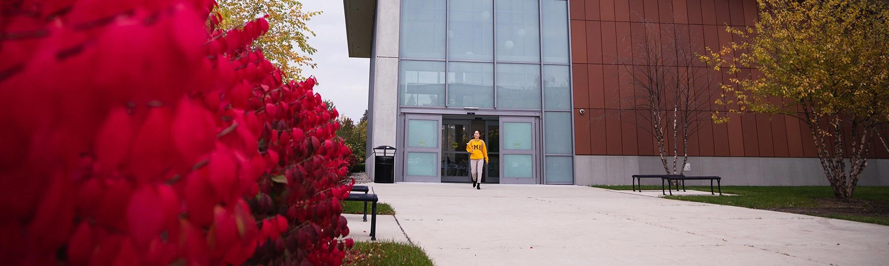 A student in a yellow shirt exits the BioSciences building.