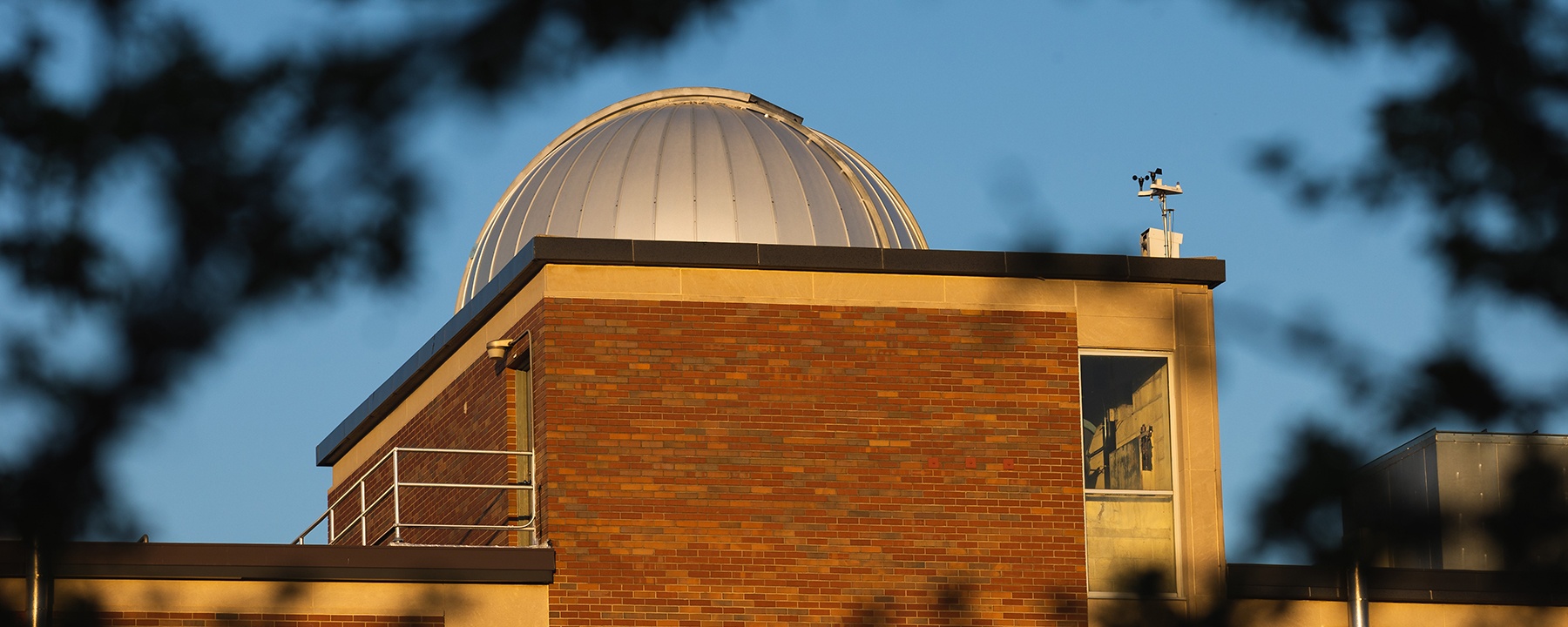 A distant view of Brooks Hall Astronomical Observatory during the daytime.