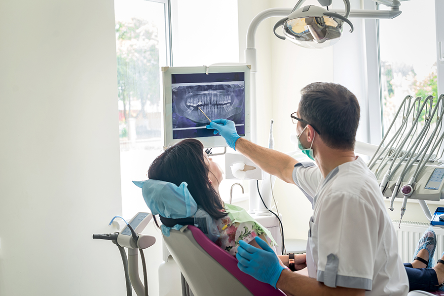A dentist showing a patient an x-ray of their mouth.