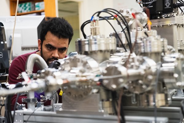 Graduate student adjusting equipment in Dr. Matt Redshaw's lab.