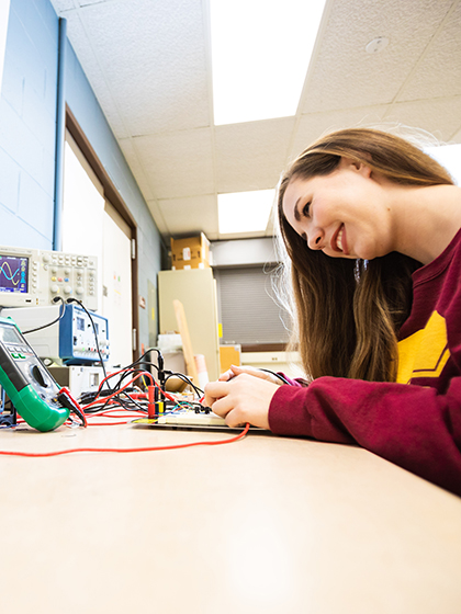 Engineering student Julia Reynolds adjusts equipment in the Electronic Engineering Lab