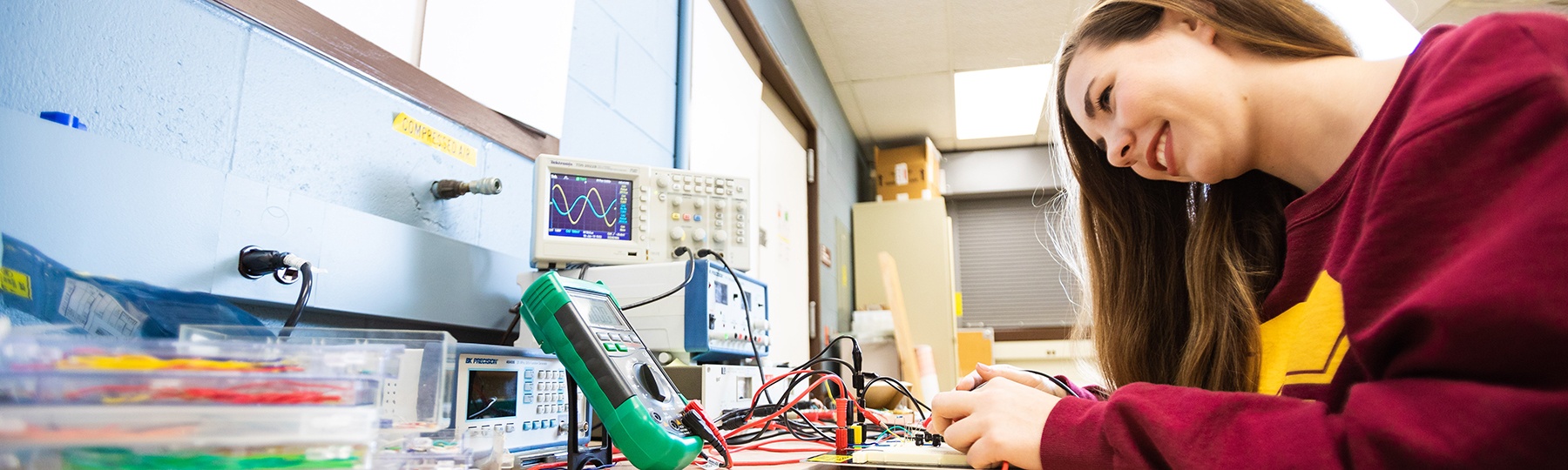 Engineering student Julia Reynolds adjusts equipment in the Electronic Engineering Lab.