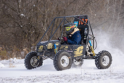 20250106_BajaTruck A student driving a CMU Baja vehicle in the snow.