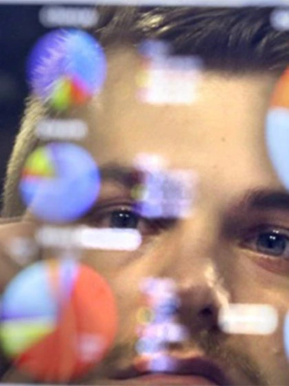 Statistics student examining computer screen full of graphs