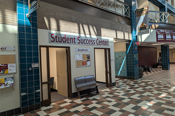 A sign above two doors that reads Student Success Center