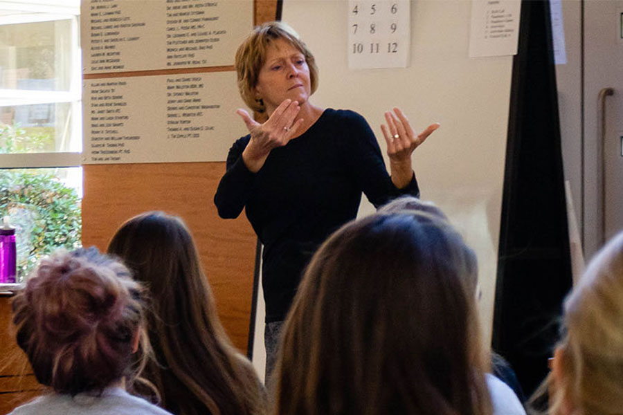 Instructor demonstrating sign language to a class