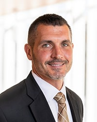 Rick Ferkel, an associate professor in the Physical Education and Sport Department, smiling for a professional headshot.