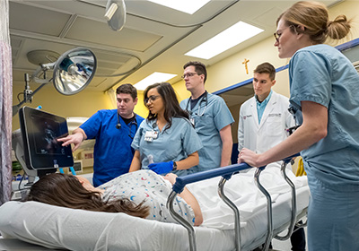Nursing and medical students examining a patient