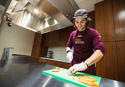 Student cutting carrots in Nutrition and Dietetics class