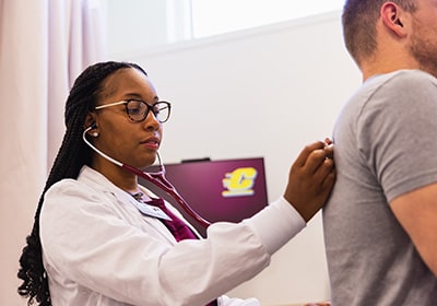 A Physician Assistant student listening to a patient's lung sounds.