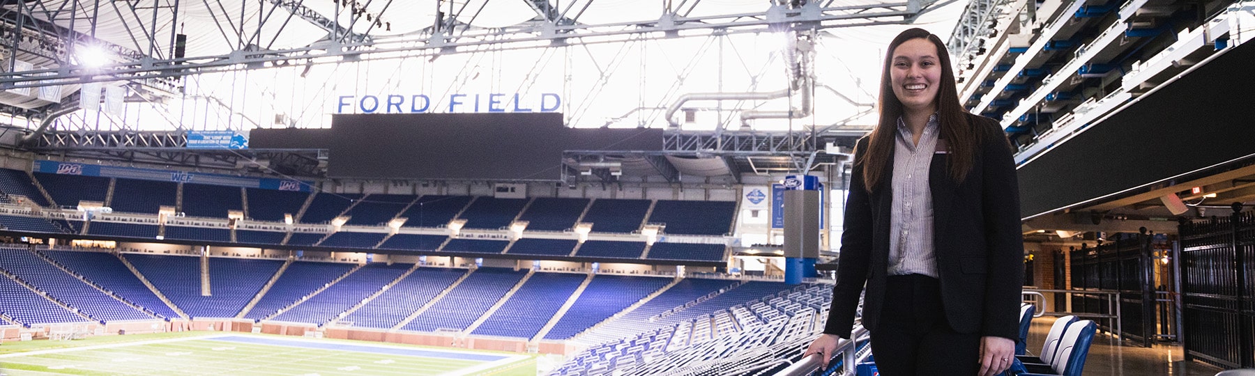 A Central Michigan University sport management student poses at Ford Football Field.