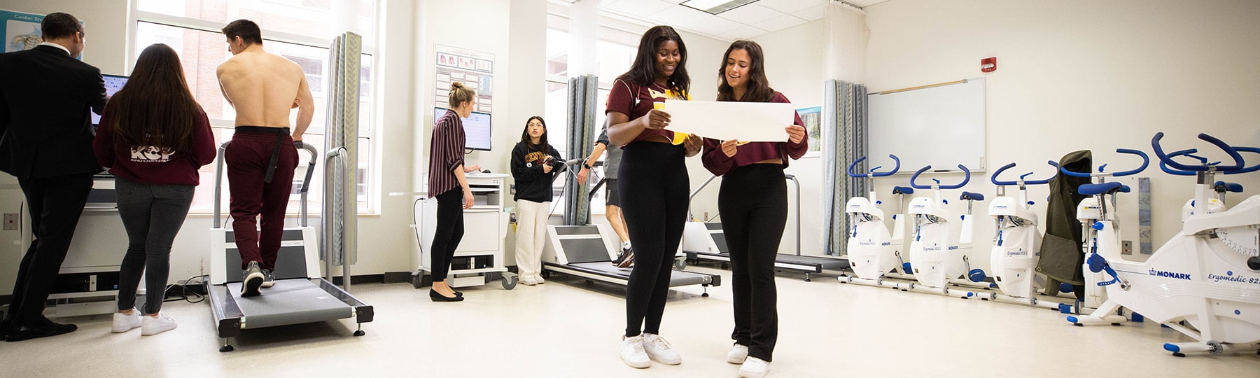 Two exercise science students exam test results in the physiology lab.