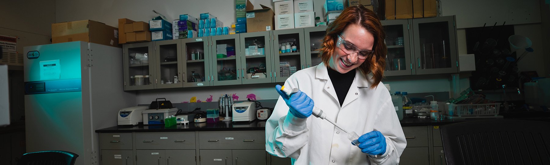 A student working with a pipette in a neuroscience lab.