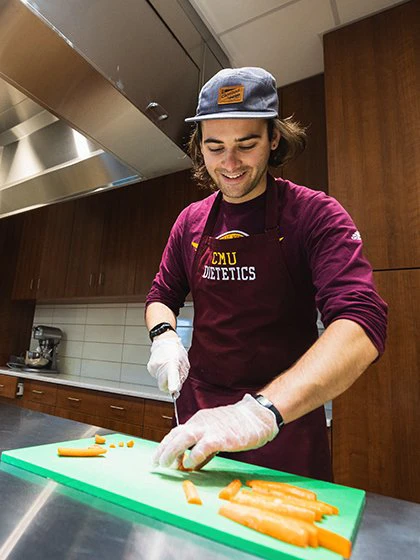 Dietetics student chopping carrots