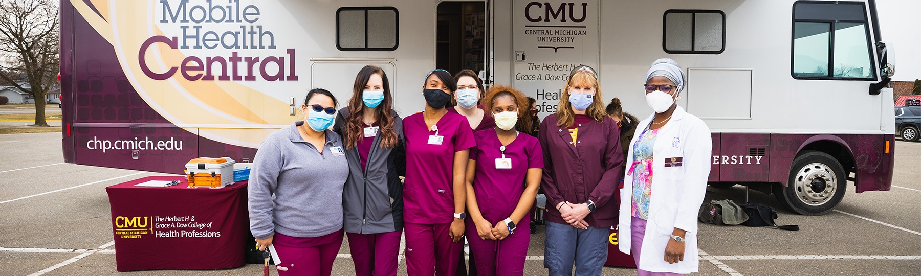 rn students standing in front of the Mobile Health Central bus