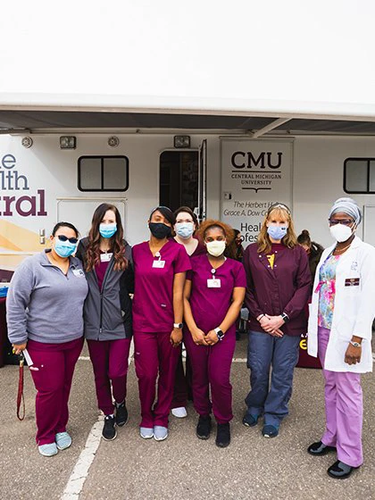 rn students standing in front of the Mobile Health Central bus