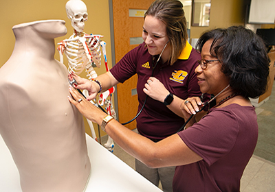 Athletic training student and faculty in a lab