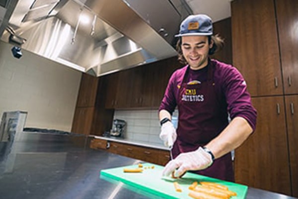 A student prepares food in the culinary center.