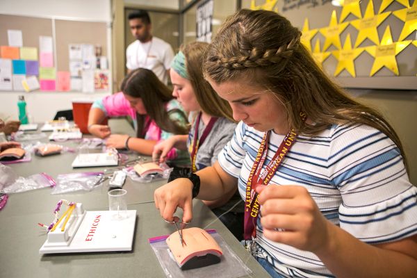 Student practicing suturing at a table