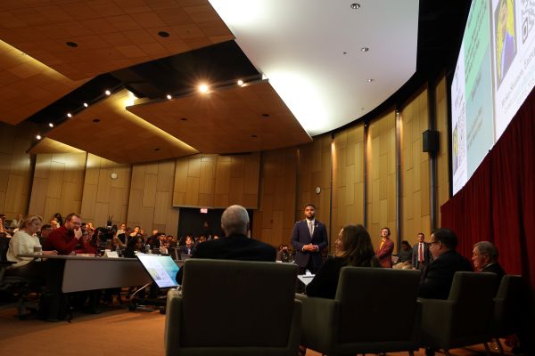 Student standing in front of a crowd in French Auditorium in the EHS Building at CMU