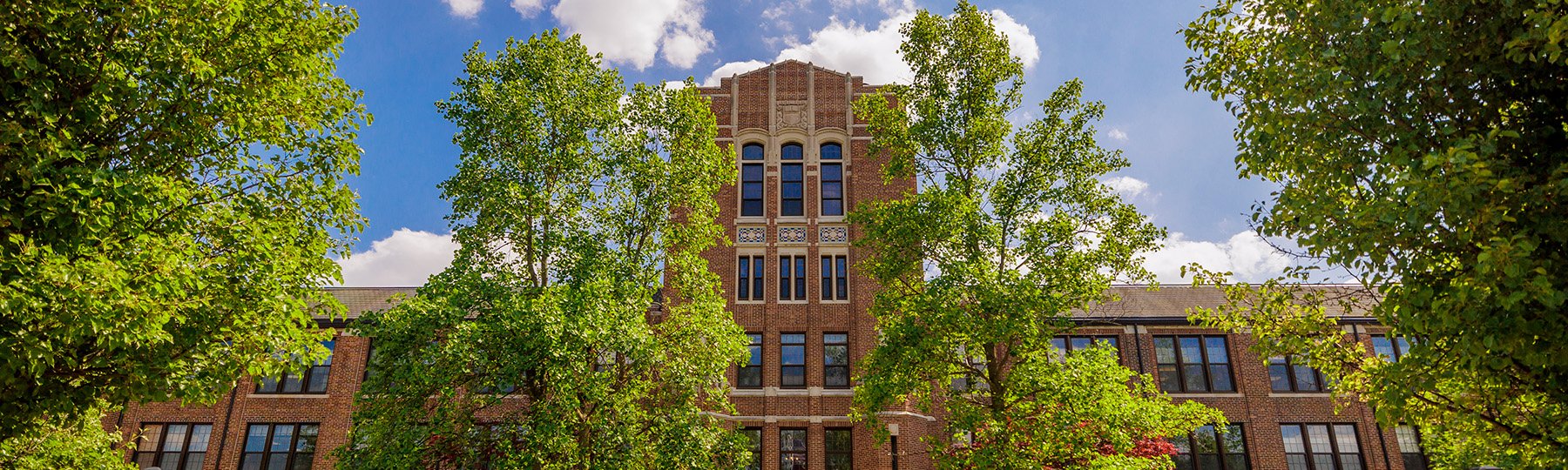 Straight-on view of Warriner Hall on a bright summer day.