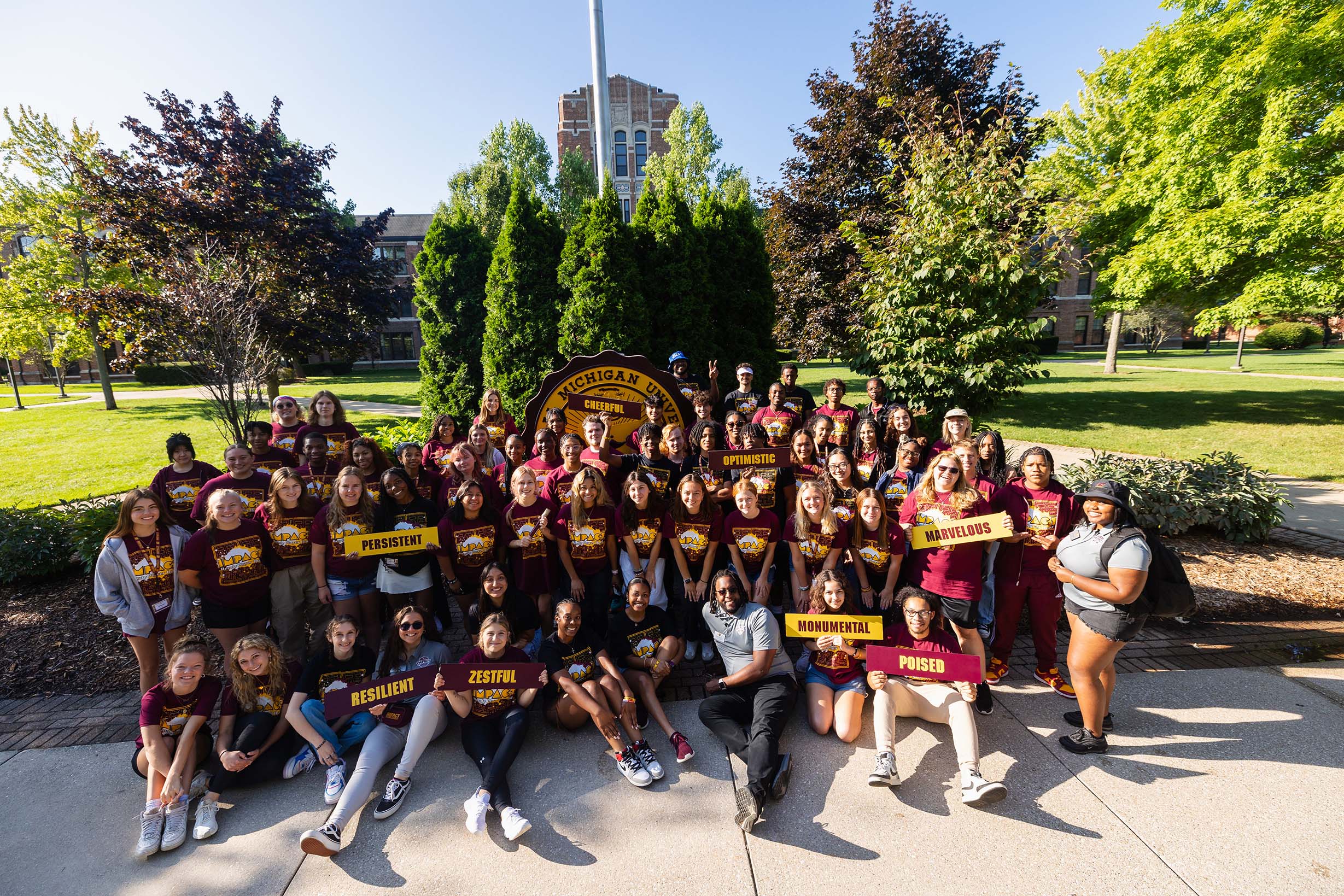24-08-19 IMPACT Family Photos-0002_RESIZED 2024 IMPACT team group photo in front of CMU Seal at Warriner Mall.