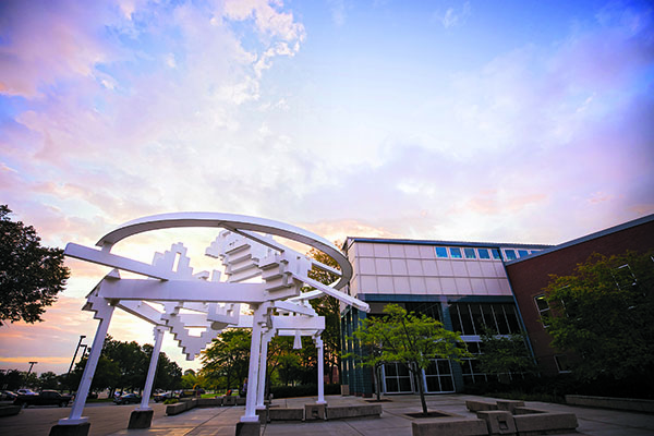Evening sky on campus of CMU with sculpture in courtyard.