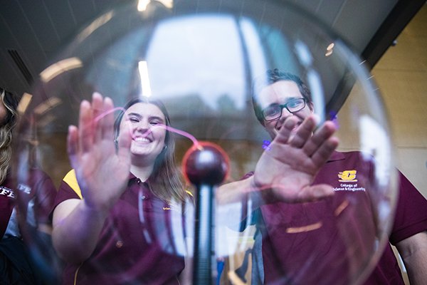 Students looking through globe