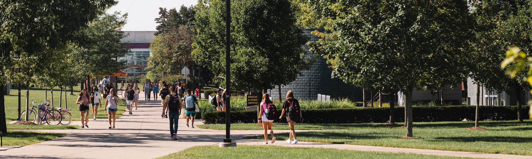 Students walking on campus on a sunny day.