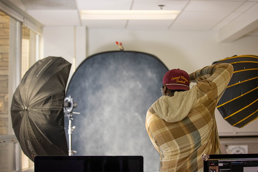 24-10-18 Skeleton Campaign MH-6 Student photographer taking professional portrait in studio with backdrop and lights.