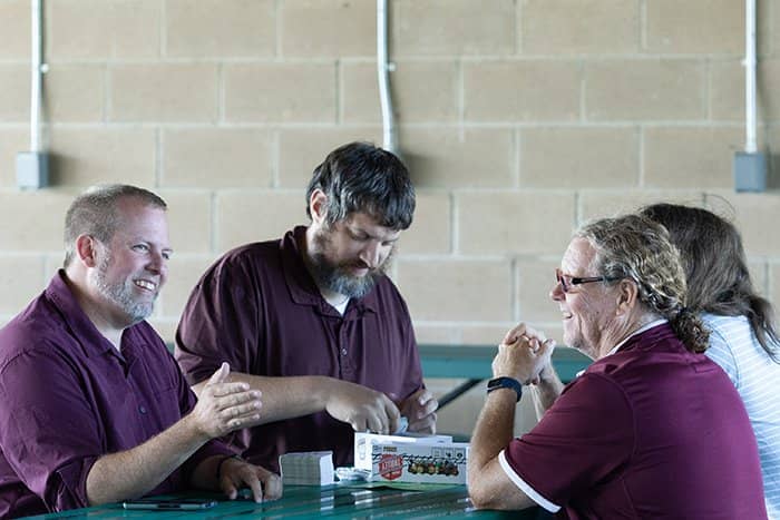 Four OIT staff members share a laugh while playing a card game.