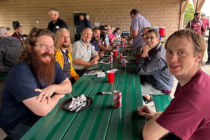 OIT staff seated at a picnic table looking into the camera and smiling.