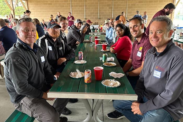OIT staff seated at a picnic table looking into the camera and smiling.