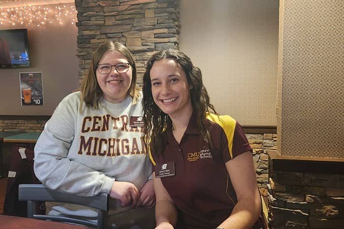 Nicole and Ashley pose for a photo at Riverwood. Both are wearing CMU apparel.